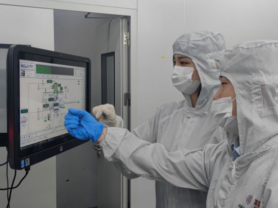 宋學穎(左)正在查看工藝和設備情況。新華社發(fā)